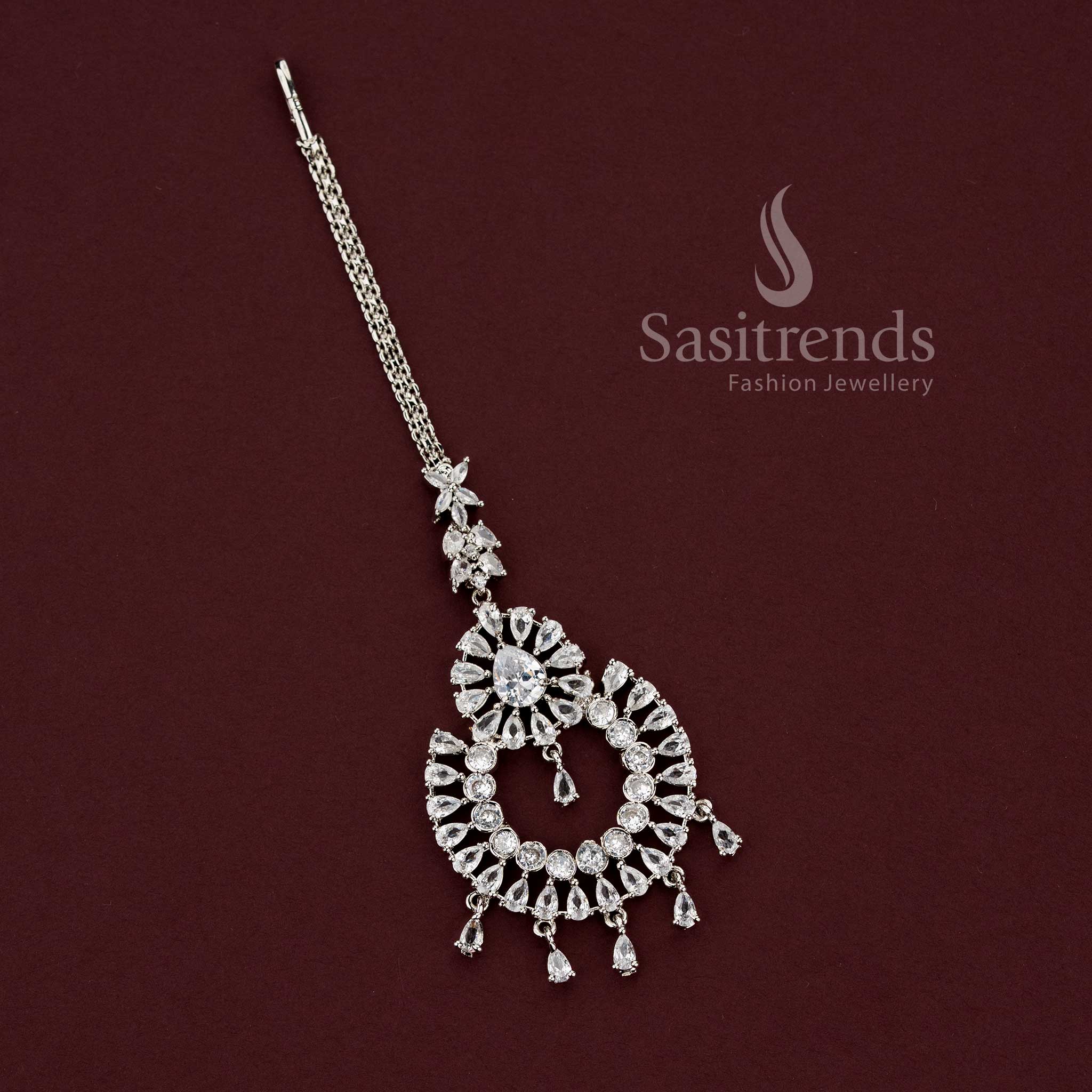 Elegant rhodium silver plated American Diamond maang tikka featuring a teardrop floral motif and dangling drops, perfect for party wear and saree styling - Sasitrends
