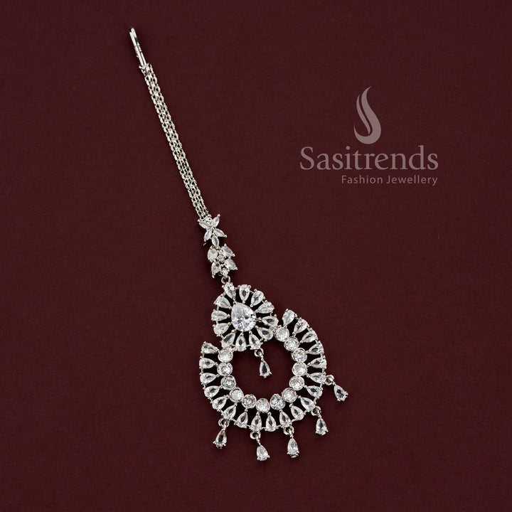 Elegant rhodium silver plated American Diamond maang tikka featuring a teardrop floral motif and dangling drops, perfect for party wear and saree styling - Sasitrends