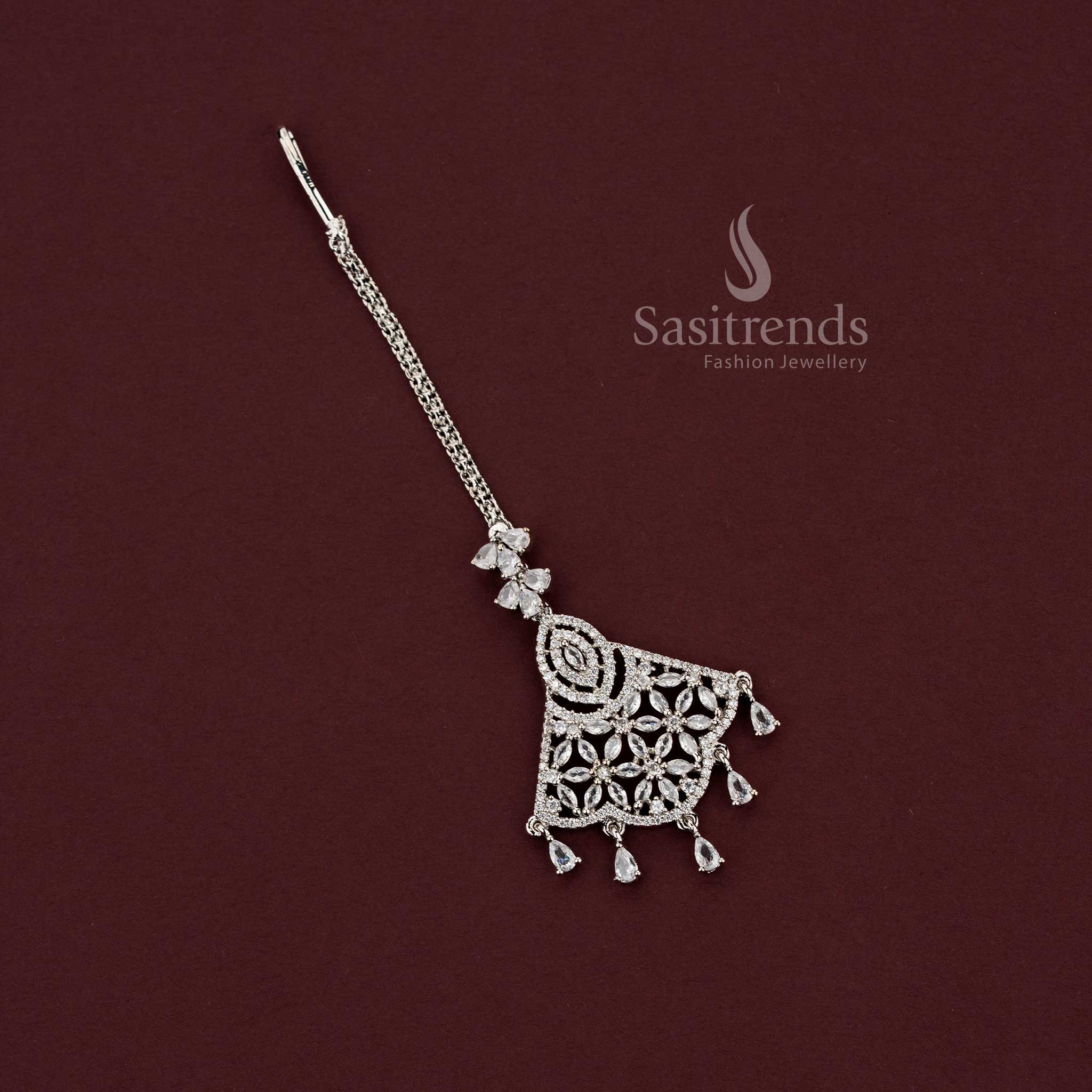 Sophisticated engagement silver AD stone maang tikka 2129G with an intricate multi-stone floral motif and dangling pear drops, ideal for styling with silk sarees and festive party wear.