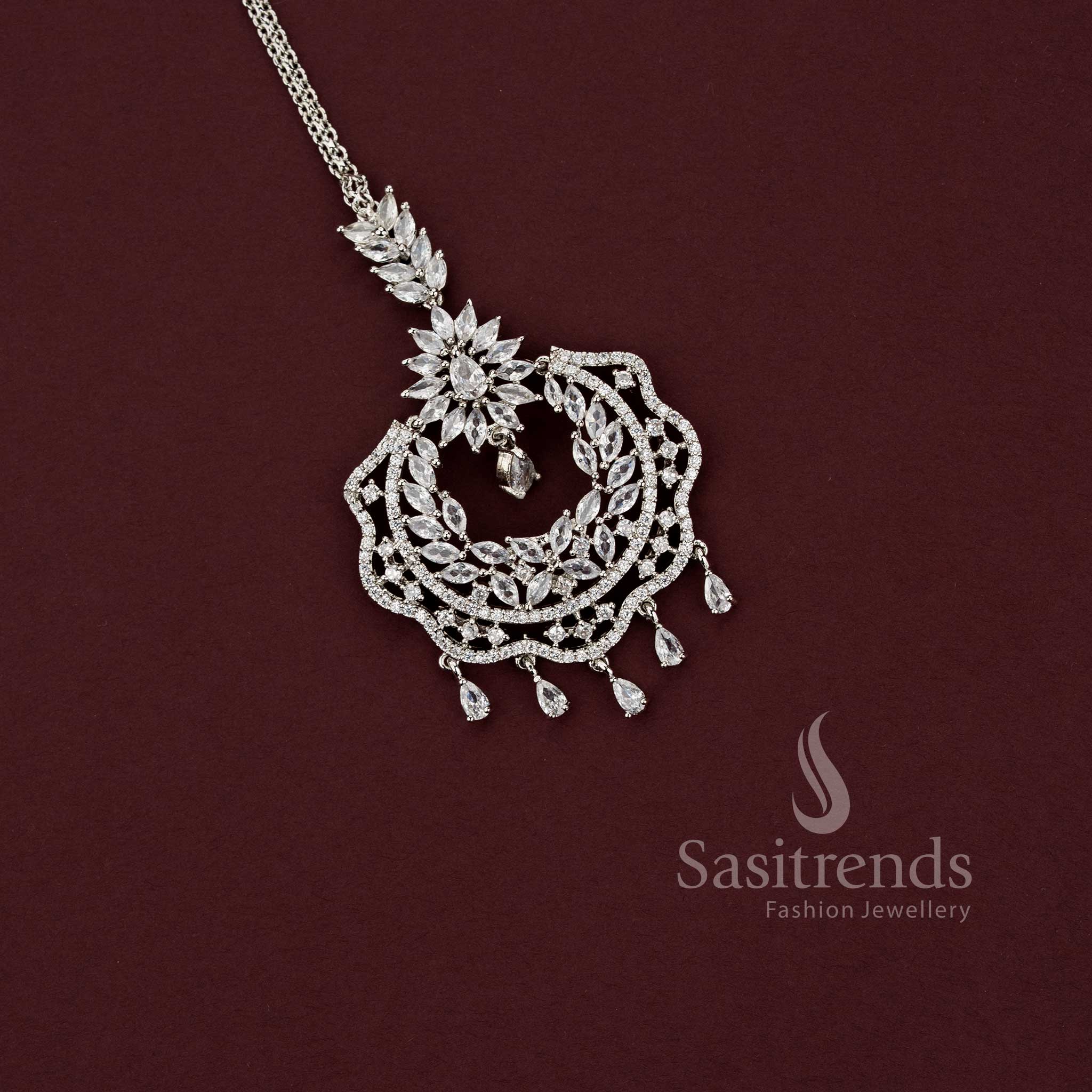 Sophisticated engagement silver AD stone maang tikka 2129H with an intricate multi-stone floral motif and dangling pear drops, ideal for styling with silk sarees and festive party wear.