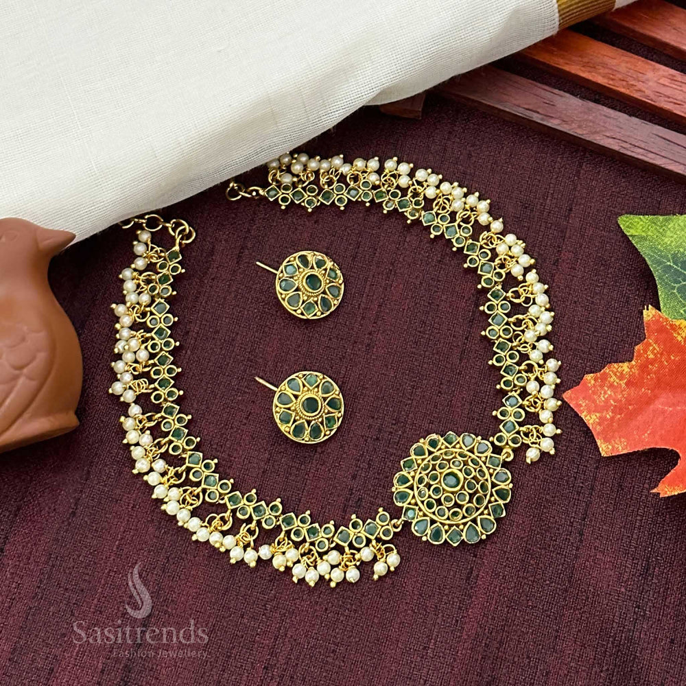 Graceful green stone temple choker jewellery set highlighted by pearl accents, matte golden finish, and a captivating floral motif pendant – Sasitrends