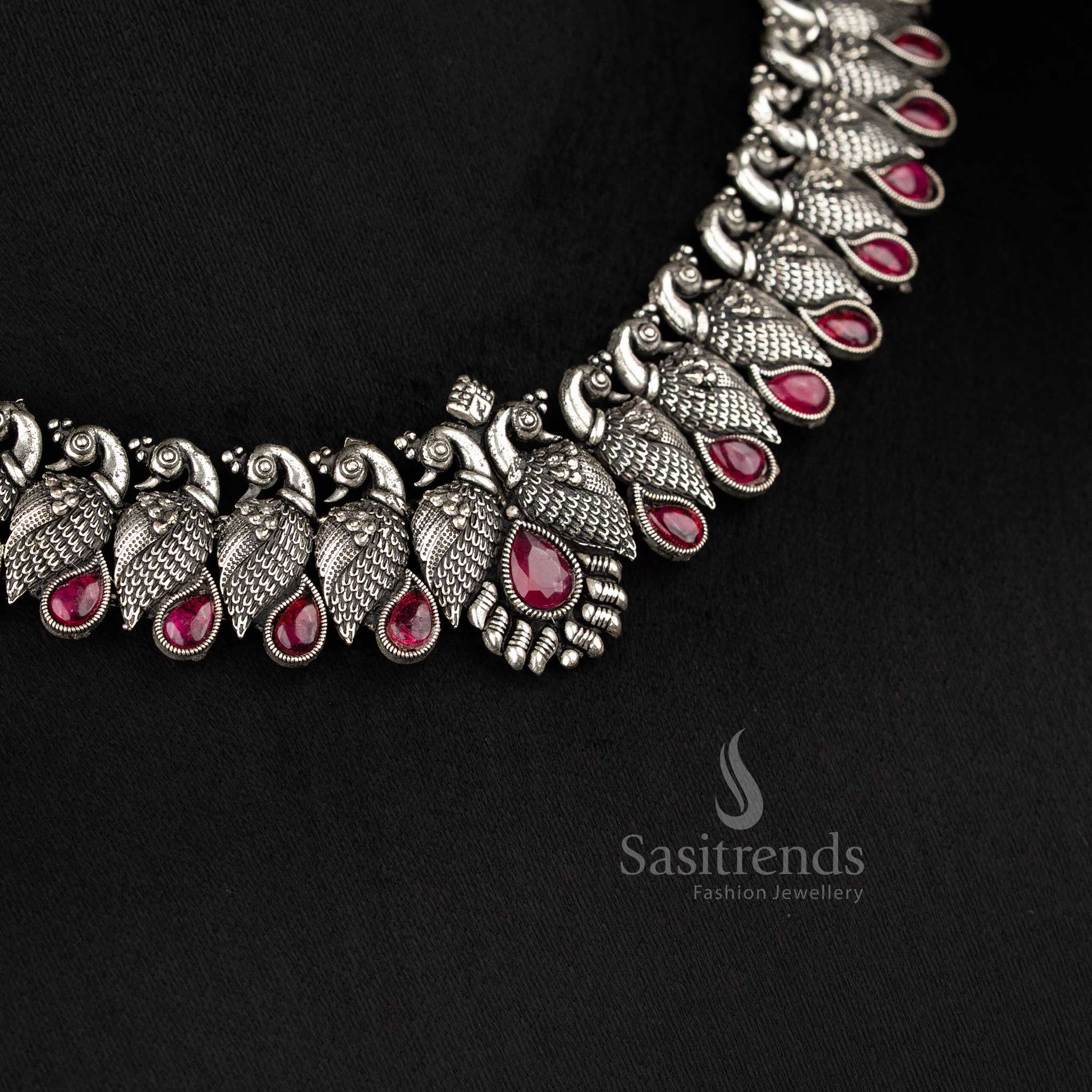 Royal handcrafted oxidised Kushi necklace set in silver, featuring contrasting Ruby -tear drop stones and peacock-shaped earrings - Sasitrends  