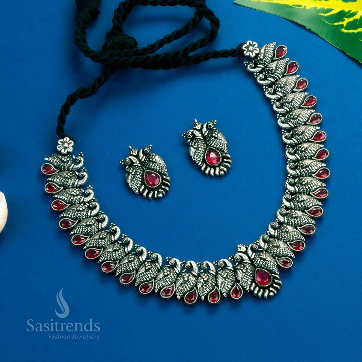 Majestic oxidised silver Kushi necklace set embellished with vibrant ruby tear drop stones and detailed earrings - Sasitrends