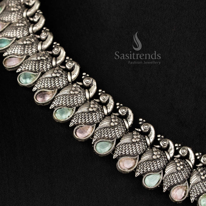 Royal handcrafted oxidised Kushi necklace set in silver, featuring contrasting Ruby -tear drop stones and peacock-shaped earrings - Sasitrends  