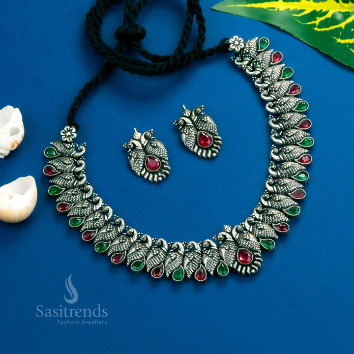Elegant antique peacock Kushi necklace set in oxidised silver, designed with ruby-green tear drop stones - Sasitrends