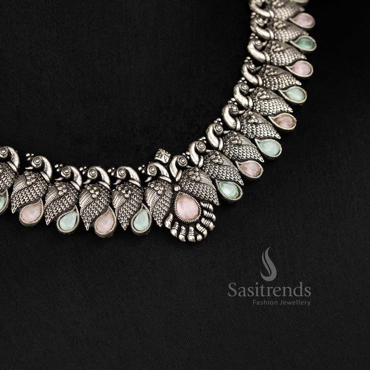 Royal handcrafted oxidised Kushi necklace set in silver, featuring contrasting pink mint -tear drop stones and peacock-shaped earrings - Sasitrends 