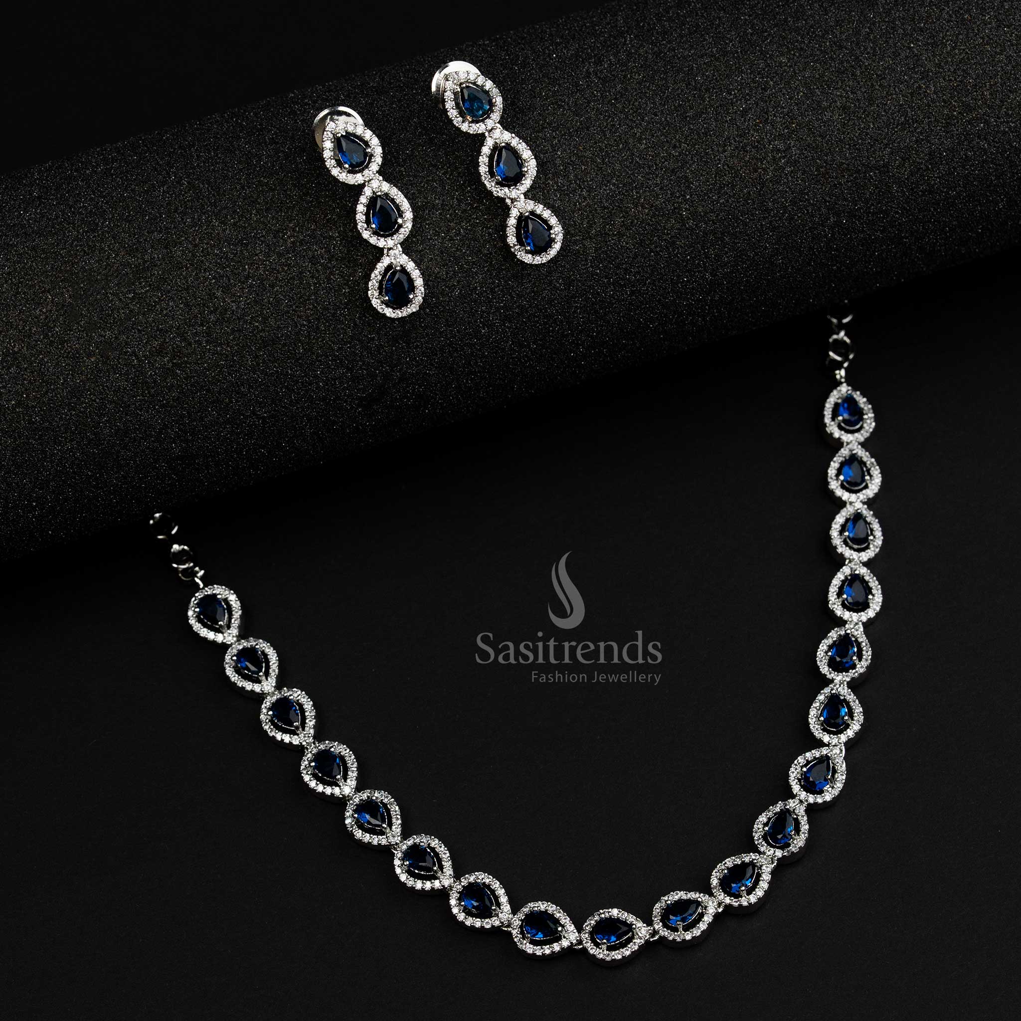 Stylish rhodium silver plated jewellery set with striking blue American Diamond stones, crafted in a Thilak pattern, perfect for trendy party wear looks - Sasitrends