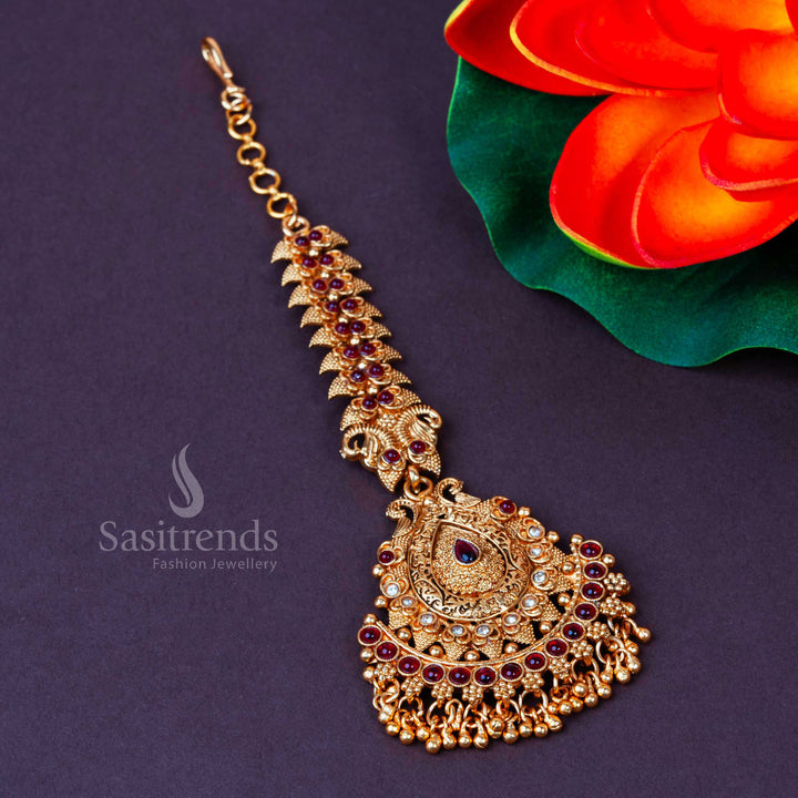Matte gold plated temple maang tikka with elegant white and ruby stones, intricate bead hangings, a perfect bridal accessory echoing festive heritage grace and ceremonial elegance – Sasitrends