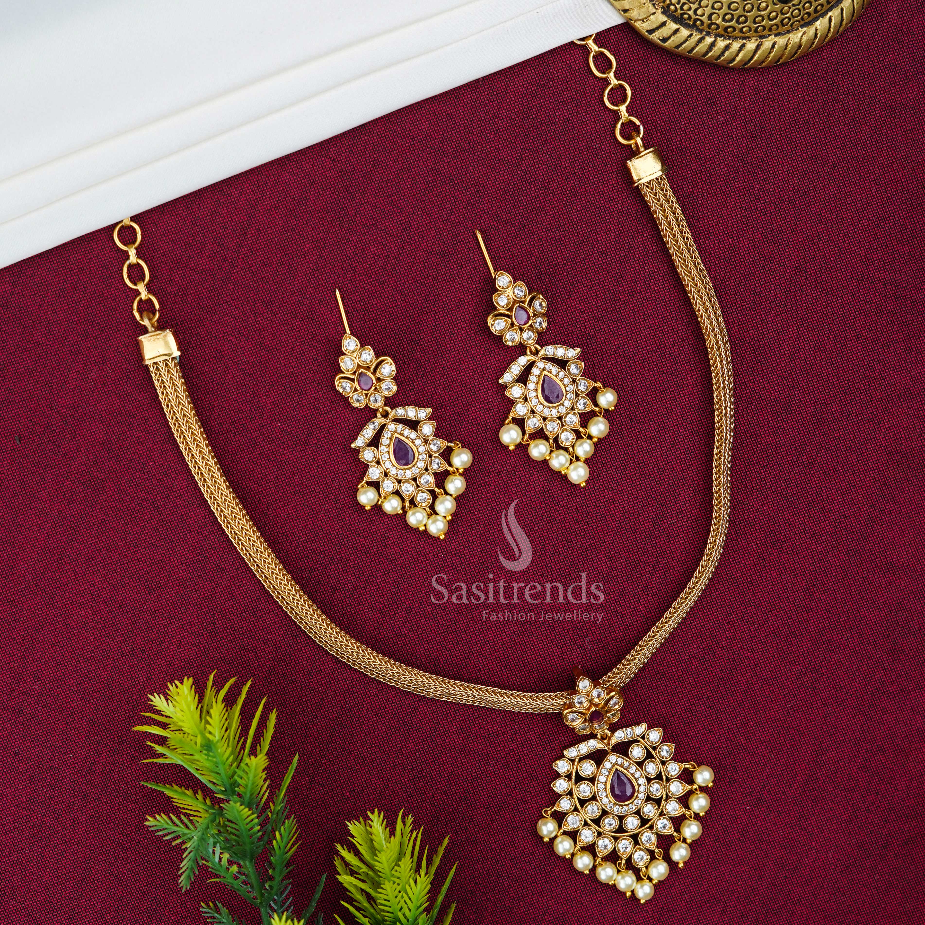 Heritage Centre Ruby Stone Matte Gold Floral Pendant Jewellery Set With Temple Design And Festive Jhumkas – A Classic Ruby-Toned Central Motif With Sacred Patterns For Traditional Grand Celebrations – Sasitrends