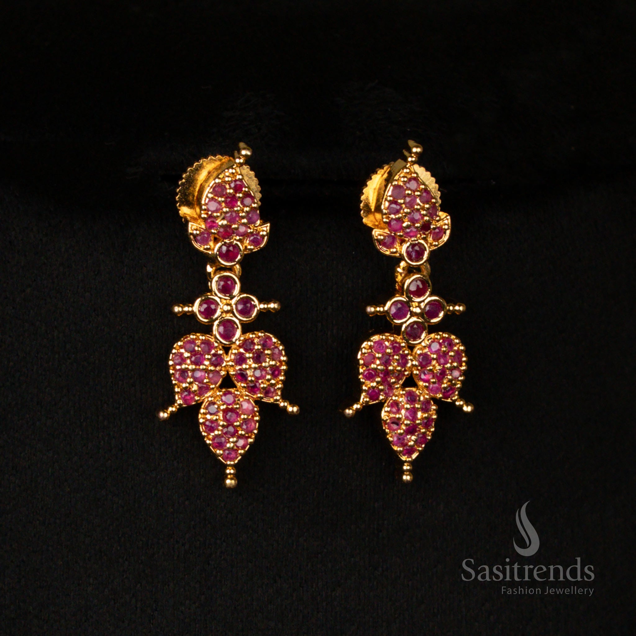 Exquisite micro gold finish earrings set with intricate leaf patterns, adorned with radiant ruby stones and sparkling American diamonds for a regal ethnic look - Sasitrends