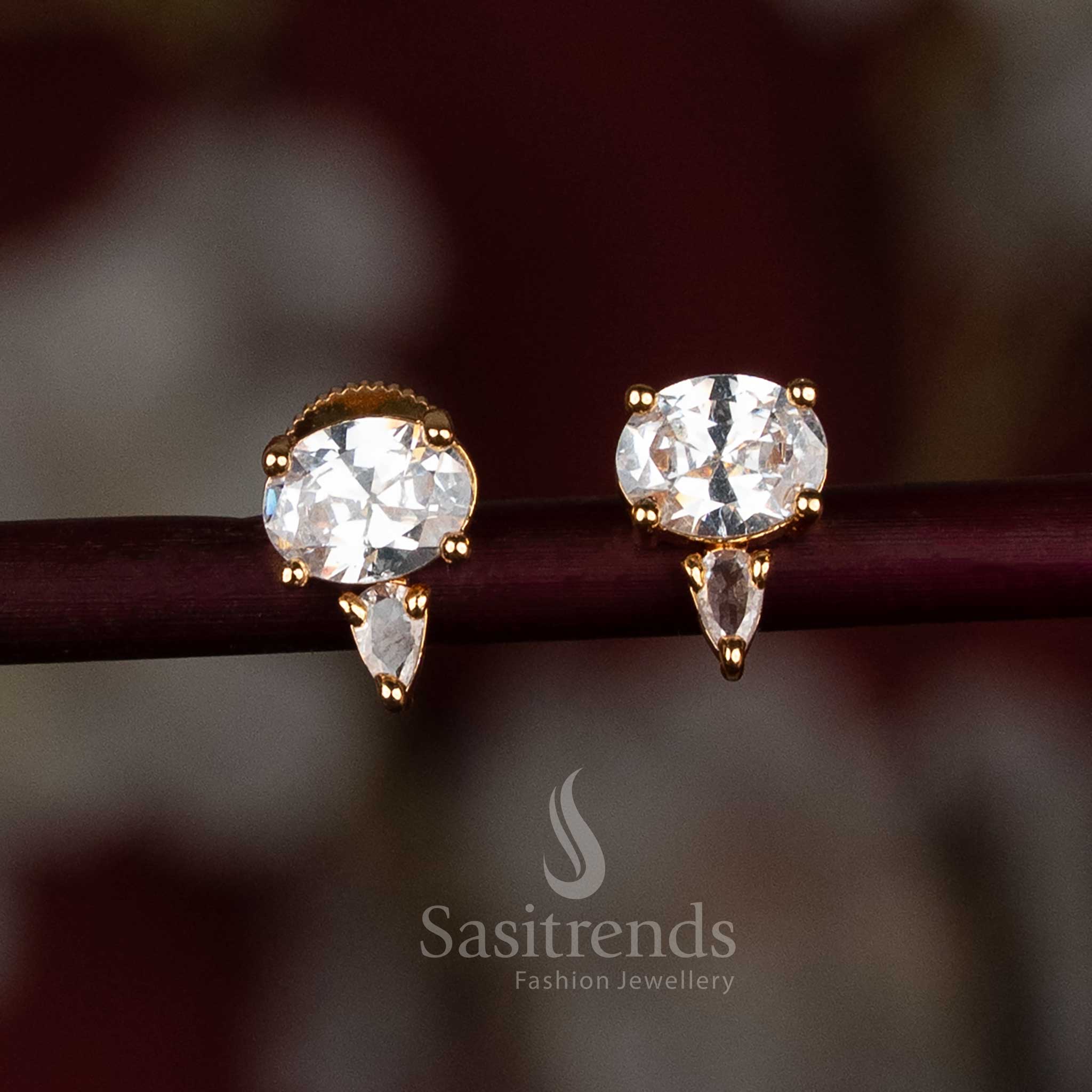 Elegant gold-plated white American Diamond stud earrings with a fusion of oval and pear-shaped stones – a classy party wear jewellery pick from Sasitrends
