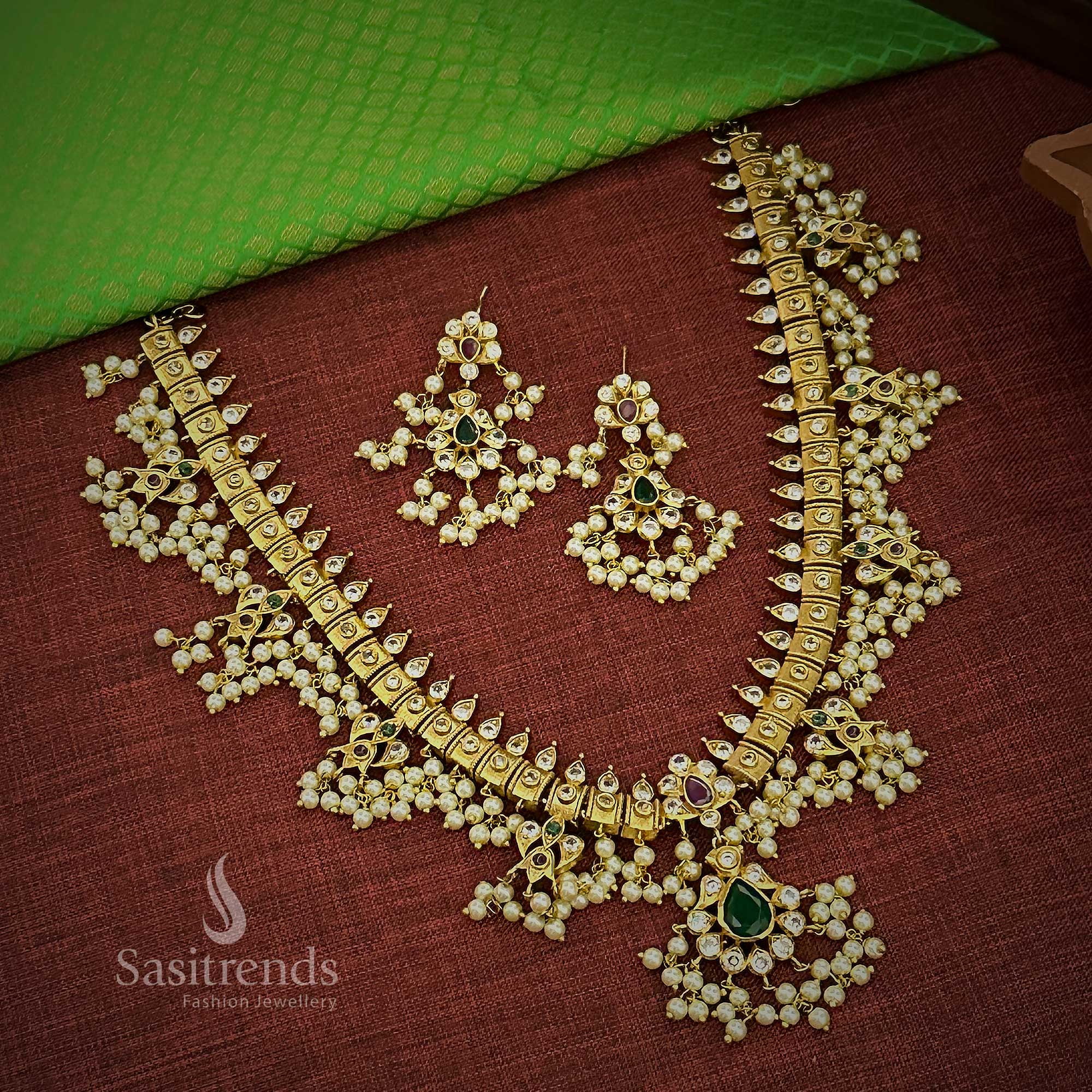 Traditional matte gold plated bridal temple jewellery set with ruby-green floral motif and pearl-laced pendant, perfect for women seeking ceremonial elegance and festive bridal finesse – Sasitrends