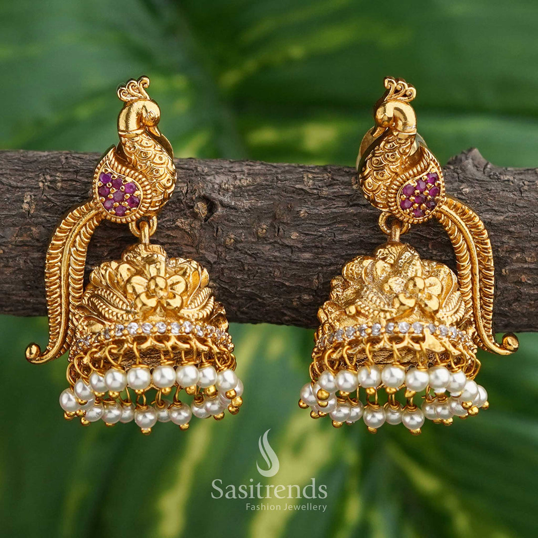 Charming ruby-hued jhumkas with divine peacock feather motifs and matte gold temple polish – a bridal favourite with rich tradition – Sasitrends