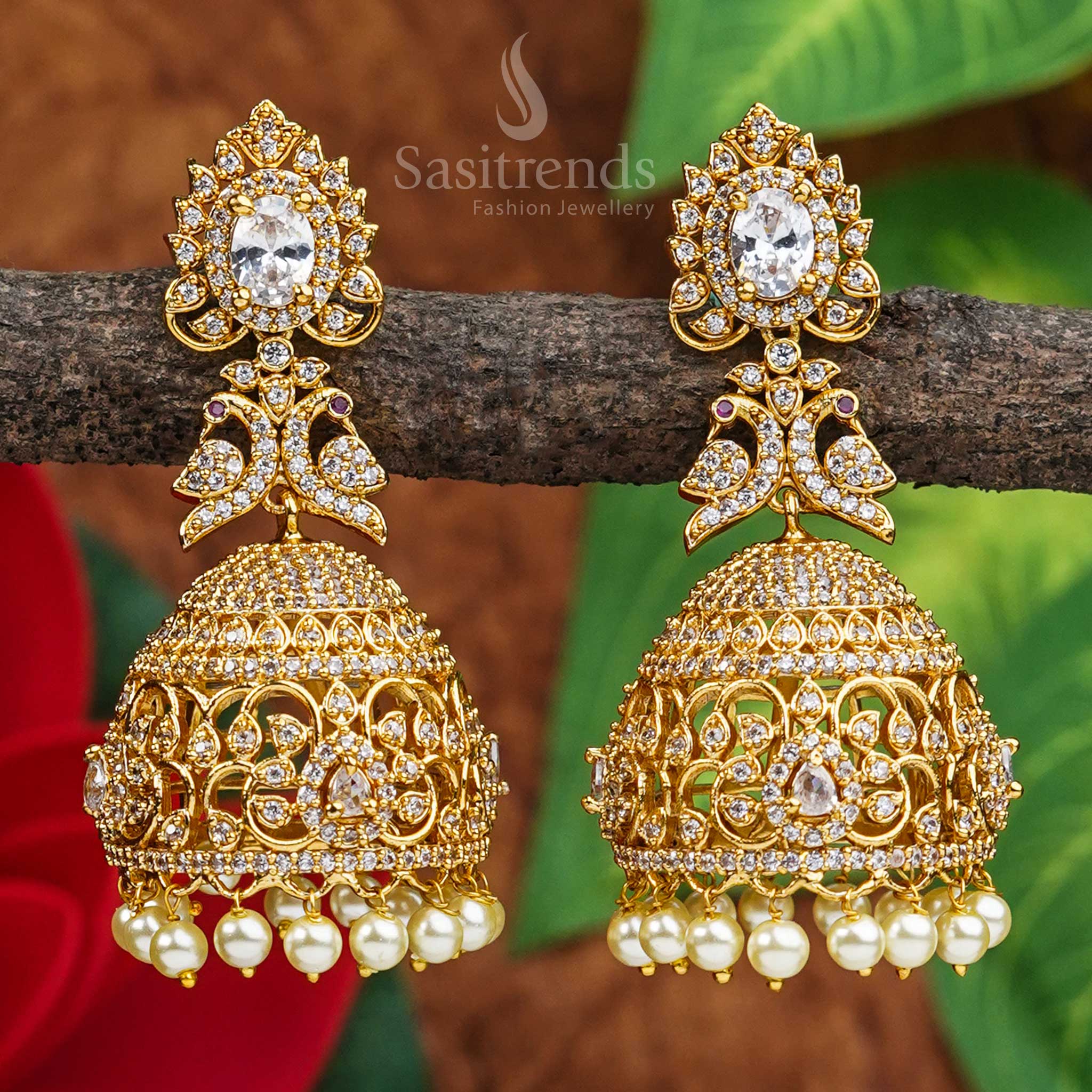 Graceful heritage elegance comes alive in these peacock bridal jhumkas, with a temple matte gold finish and white AD stones – a pristine piece of divine traditional jewellery by Sasitrends