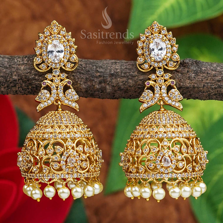 Graceful heritage elegance comes alive in these peacock bridal jhumkas, with a temple matte gold finish and white AD stones – a pristine piece of divine traditional jewellery by Sasitrends