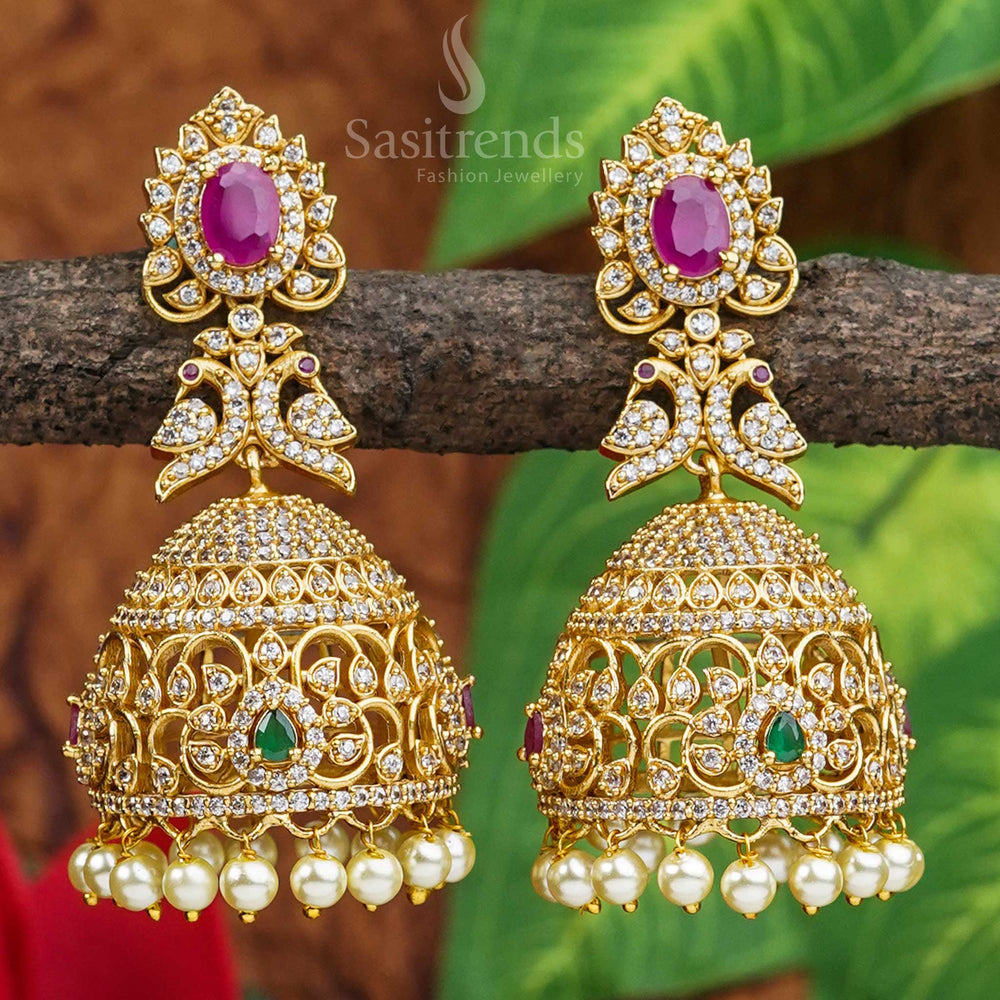 Vibrant peacock motif jhumkas crafted in matte gold with colourful AD stones, reflecting cultural heritage and vibrant ethnic artistry – jewellery inspired by temple traditions from Sasitrends