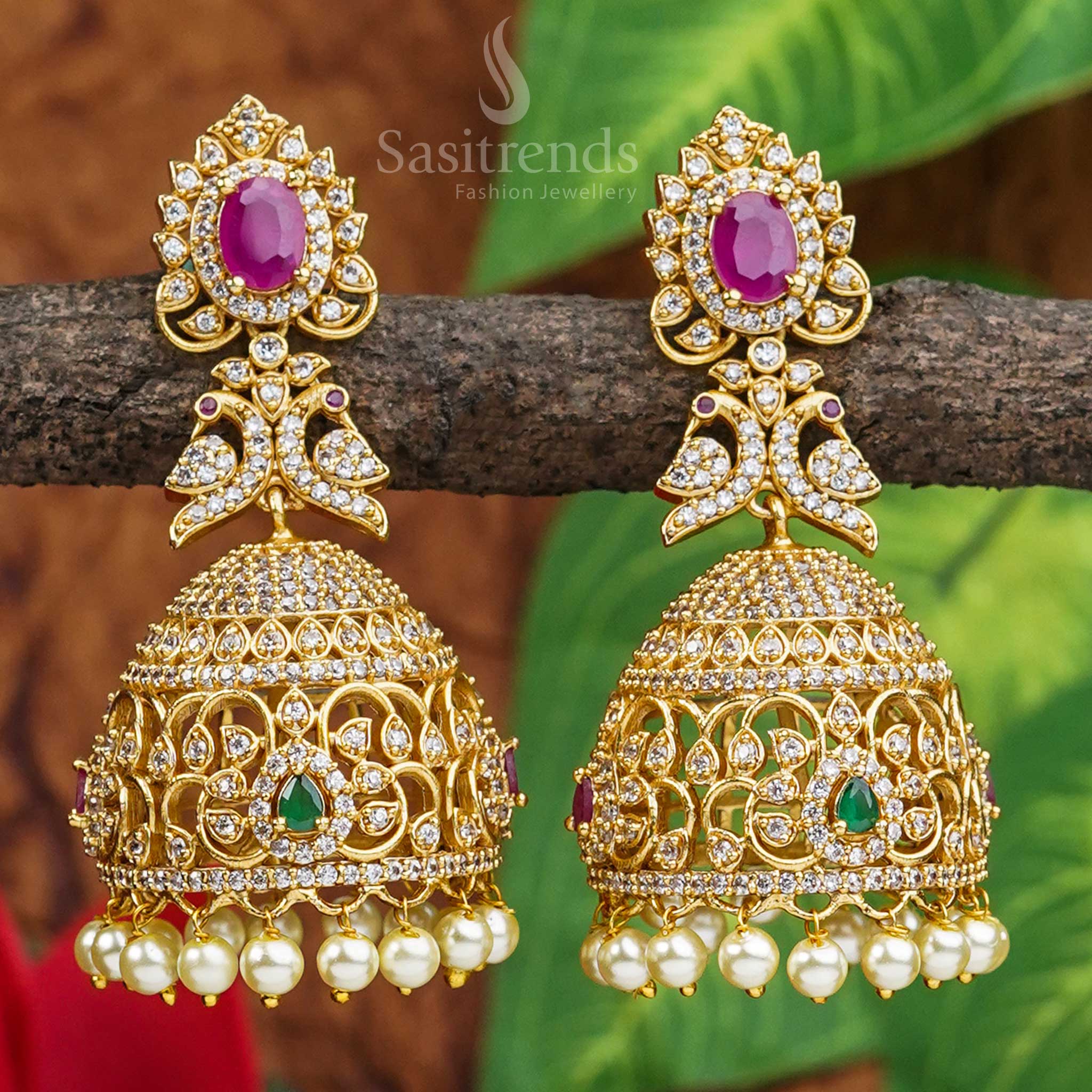 Vibrant peacock motif jhumkas crafted in matte gold with colourful AD stones, reflecting cultural heritage and vibrant ethnic artistry – jewellery inspired by temple traditions from Sasitrends