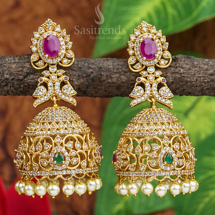 Vibrant peacock motif jhumkas crafted in matte gold with colourful AD stones, reflecting cultural heritage and vibrant ethnic artistry – jewellery inspired by temple traditions from Sasitrends