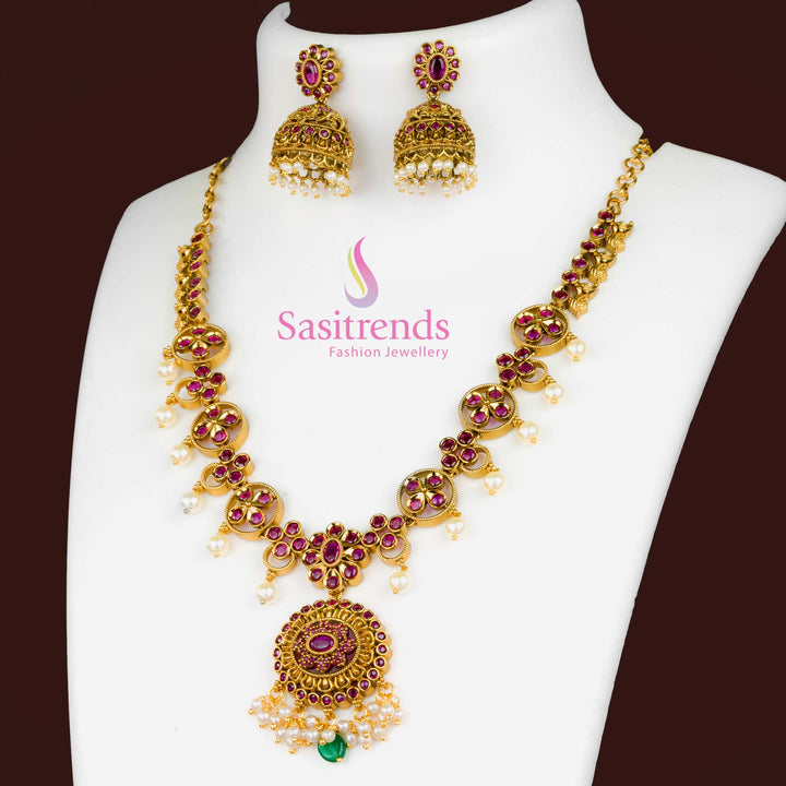 Traditional Ruby Matte Gold Plated Jewellery Set With Artistic Floral Pendant, Elegant Jhumkas, And Intricate AD Embellishments – Festive Jewellery For Sarees And Cultural Gatherings – Sasitrends