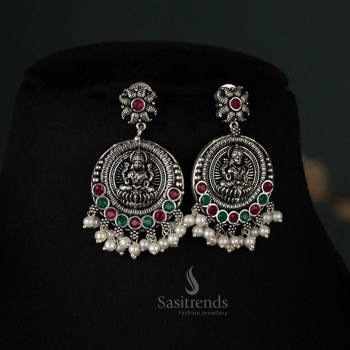 Striking oxidized earrings featuring peacock and Lakshmi pendants with pearl drops in Ruby-green, a versatile and elegant choice for any event - Sasitrends