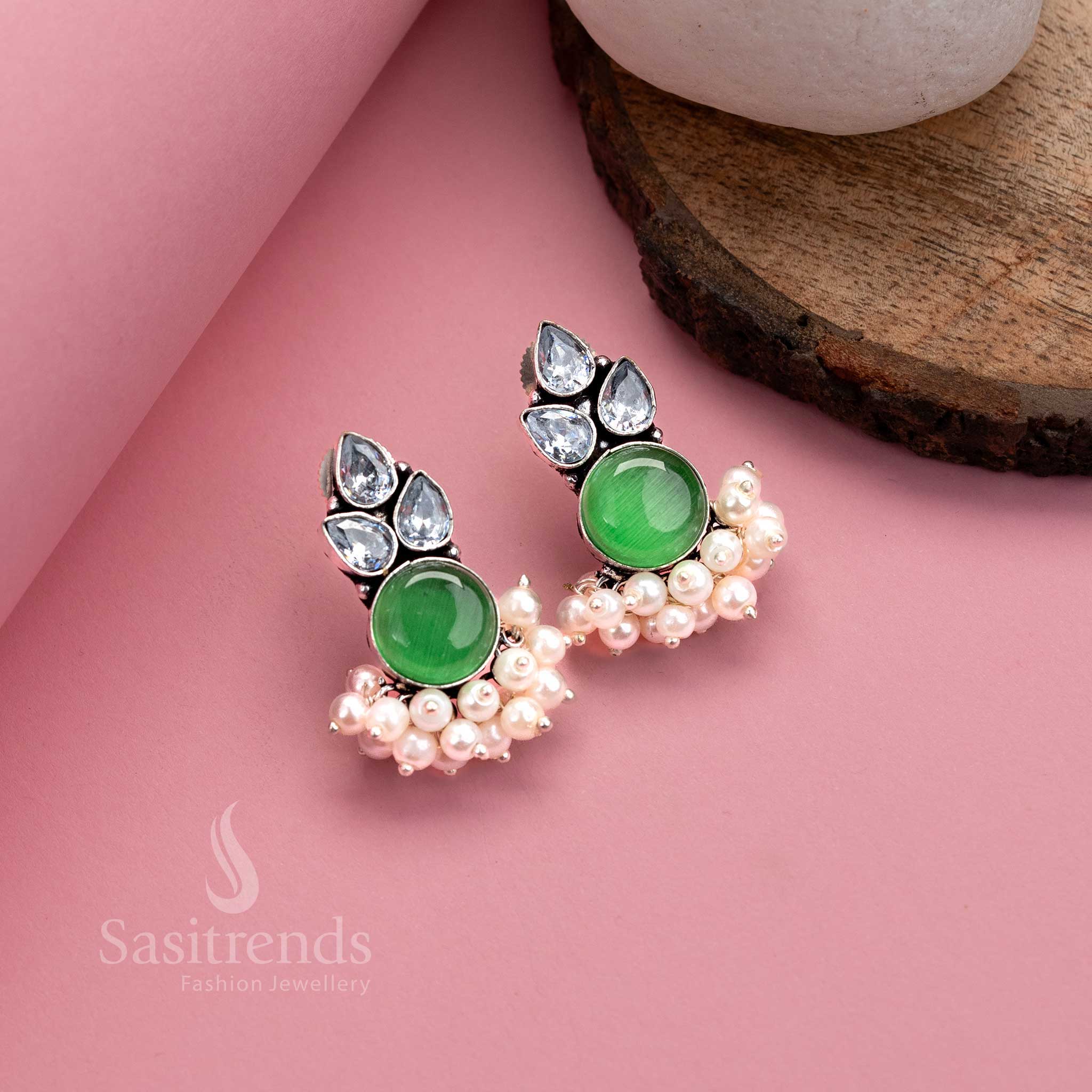Light green oxidised German silver earrings with luminous Monalisa stone, AD sparkle and elegant pearl layers – subtle festive jewellery from Sasitrends