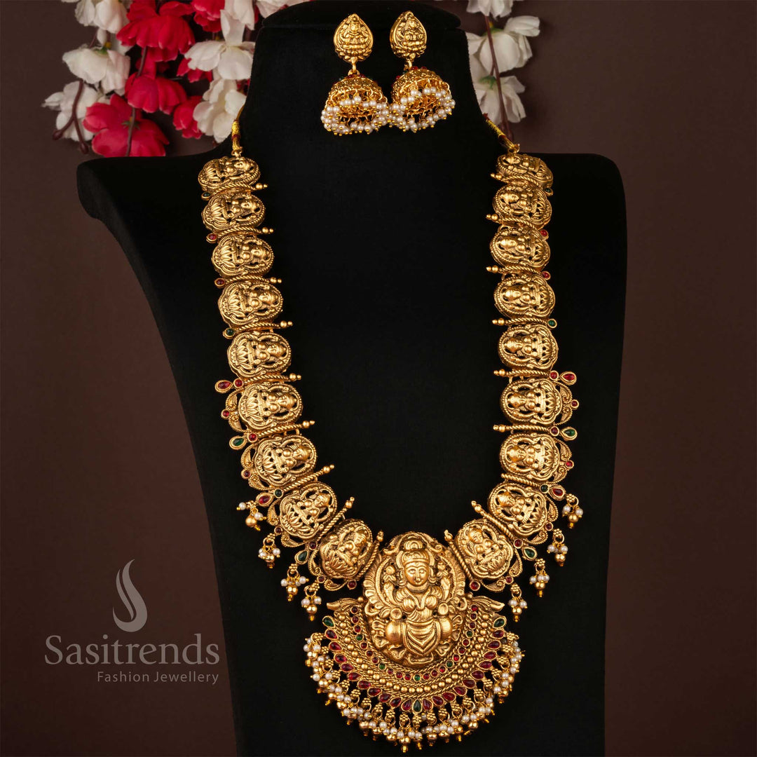 Classic matte gold plated long necklace jewellery set adorned with a divine Lakshmi pendant, intricately carved in temple heritage style, paired with grand antique jhumkas – an opulent adornment perfect for weddings and traditional celebrations – Sasitrends
