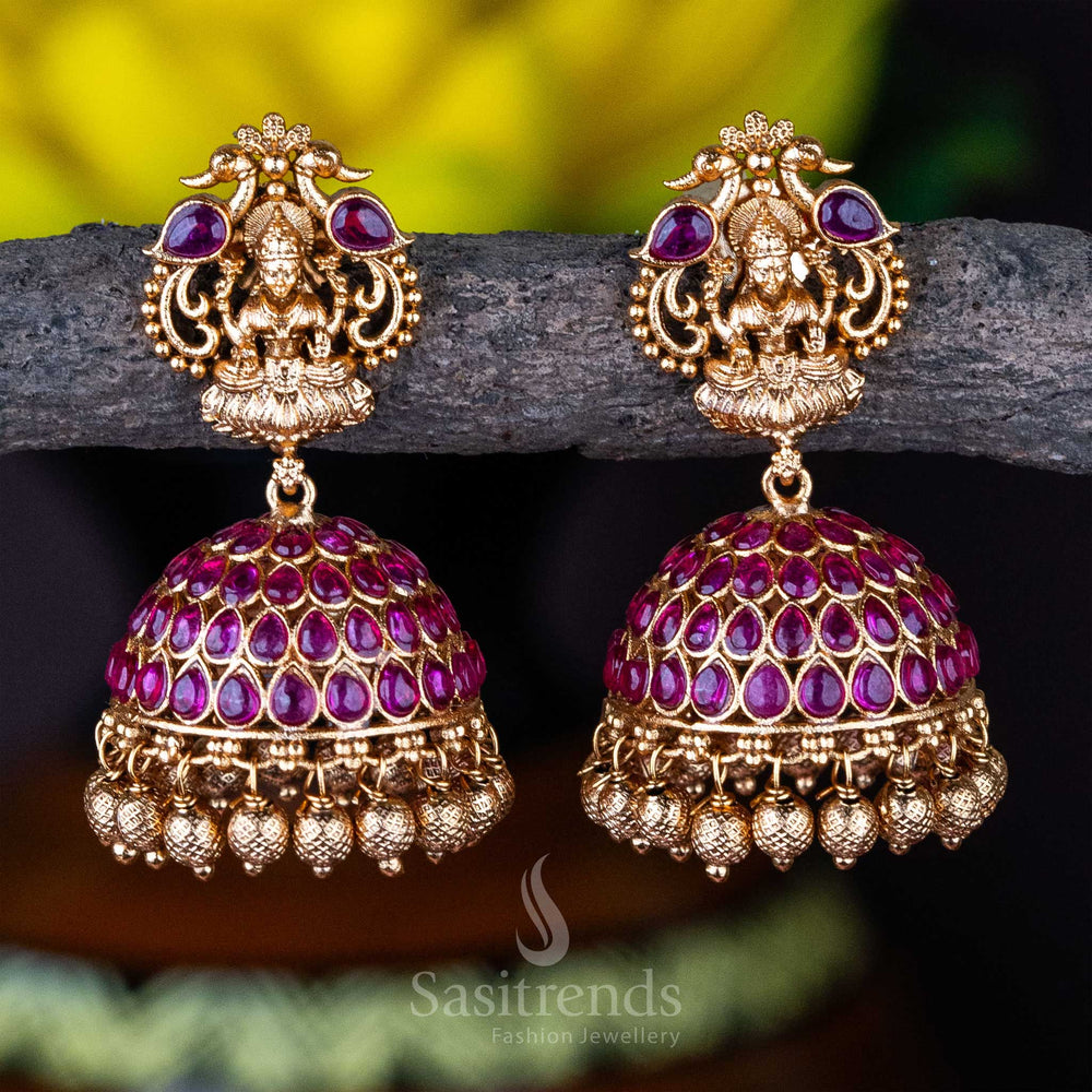 Luxury temple jewellery ruby jhumka earrings with matte gold plating, Lakshmi-peacock motif, and exquisite detailing for a grand bridal look in traditional South Indian style – sasitrends