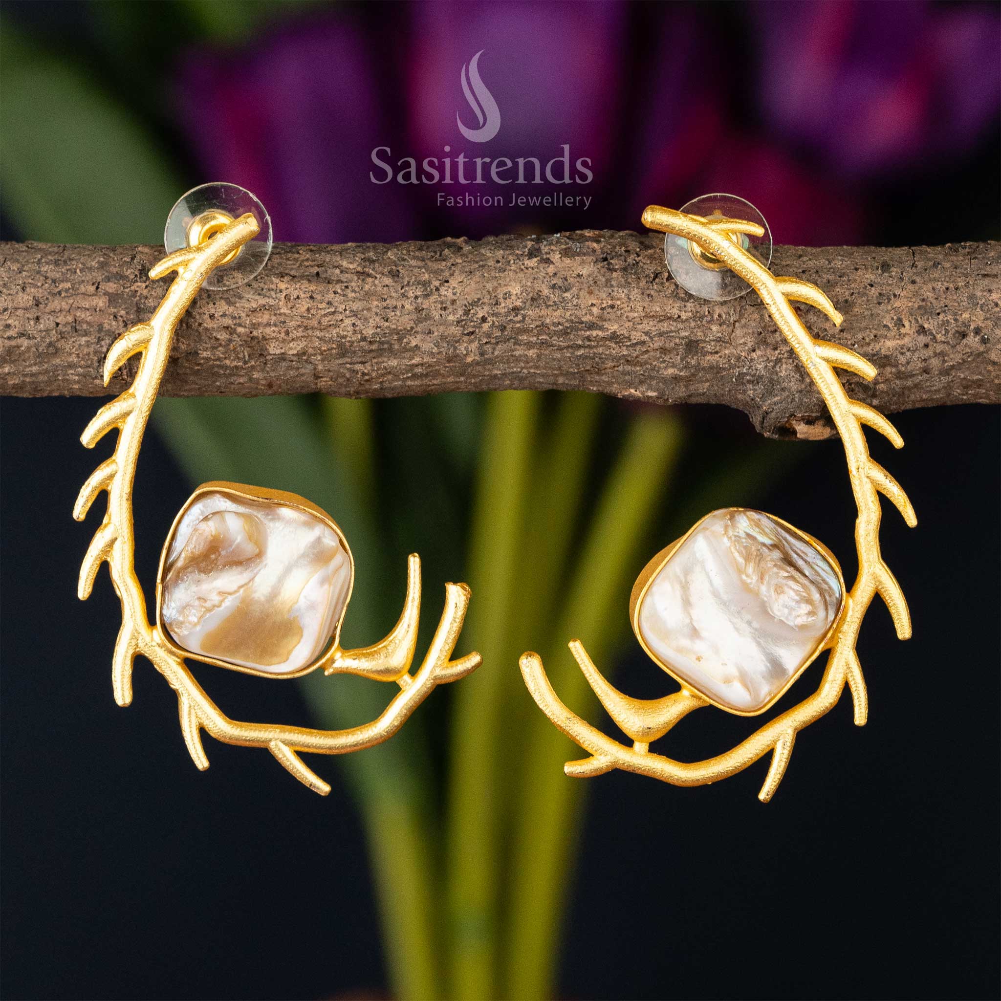 Nature-inspired gold antler earrings cradling a Mother of Pearl stone