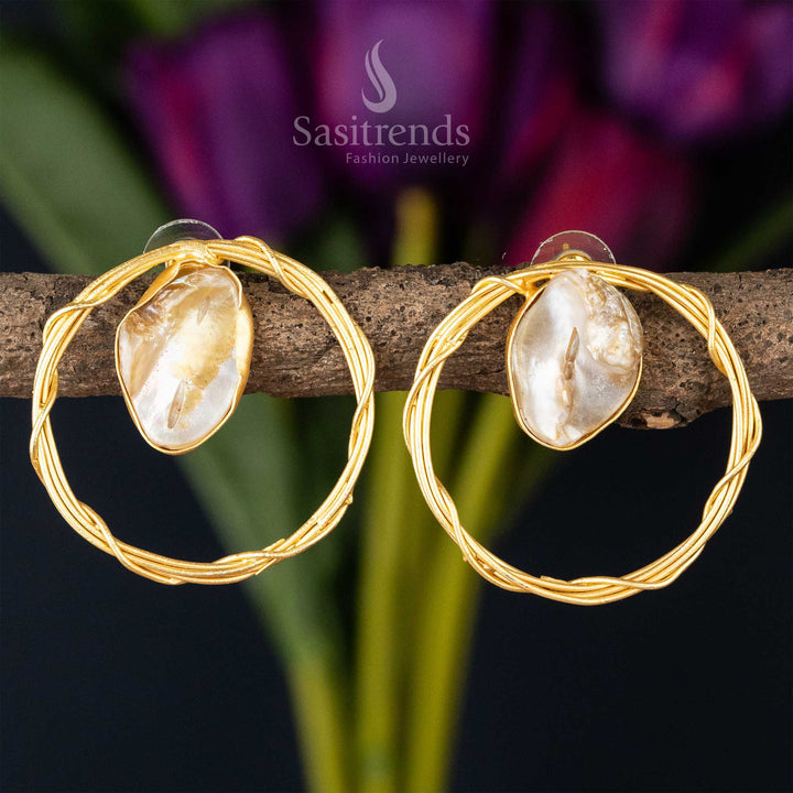 Chic twisted gold hoop earrings with a lustrous Mother of Pearl centerpiece