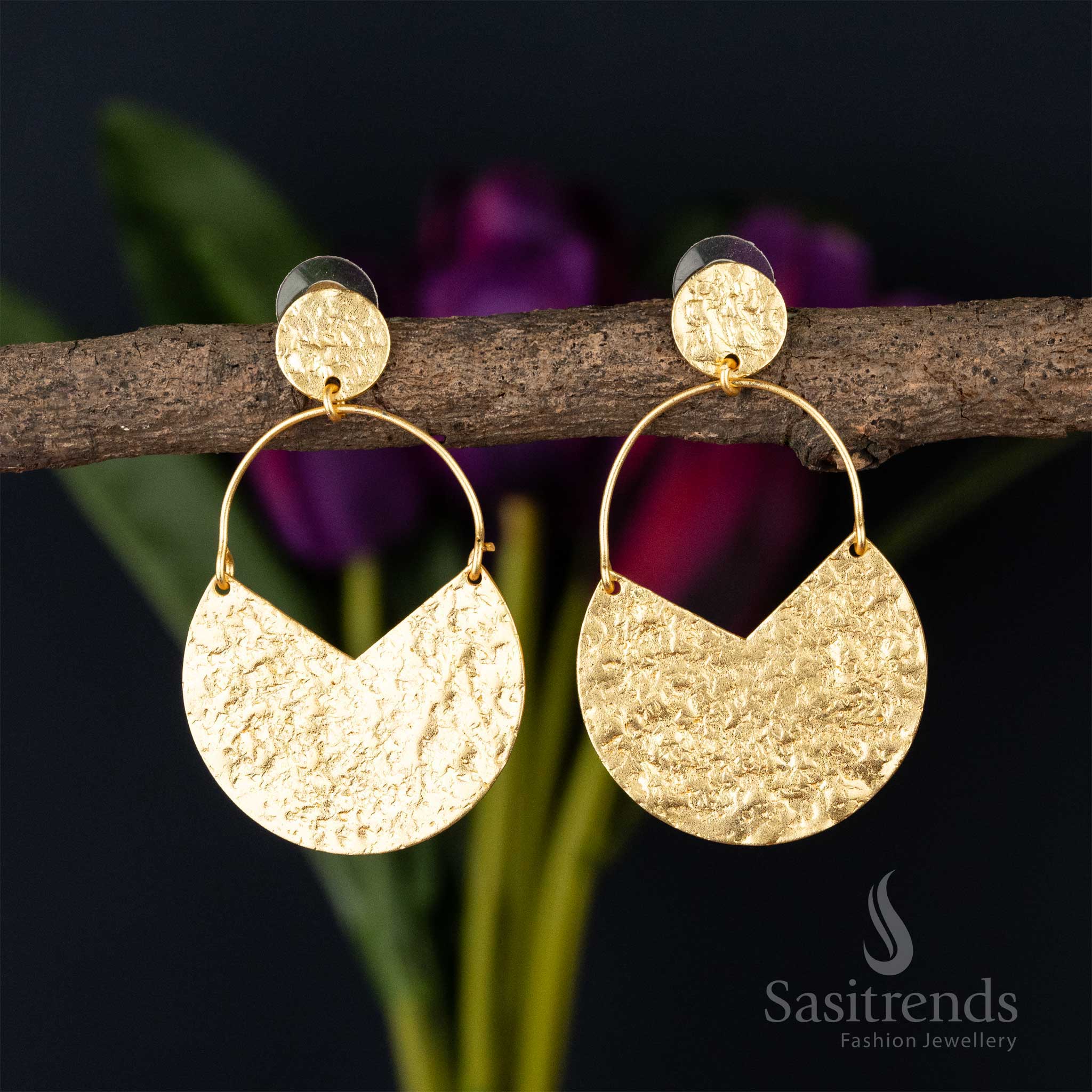Textured gold half-moon dangle earrings with circular hooks on a twig