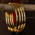 :** Set of four elegant micro gold-plated kada bangles with classic golden bead details