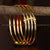 Set of four elegantly micro gold-plated kada bangles with symmetric golden bead accents