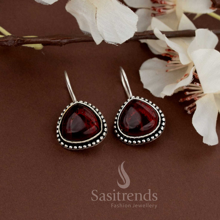 Rich-looking oxidised earrings with deep maroon teardrop stones and bead edging perfect for ethnic outings and functions from Sasitrends