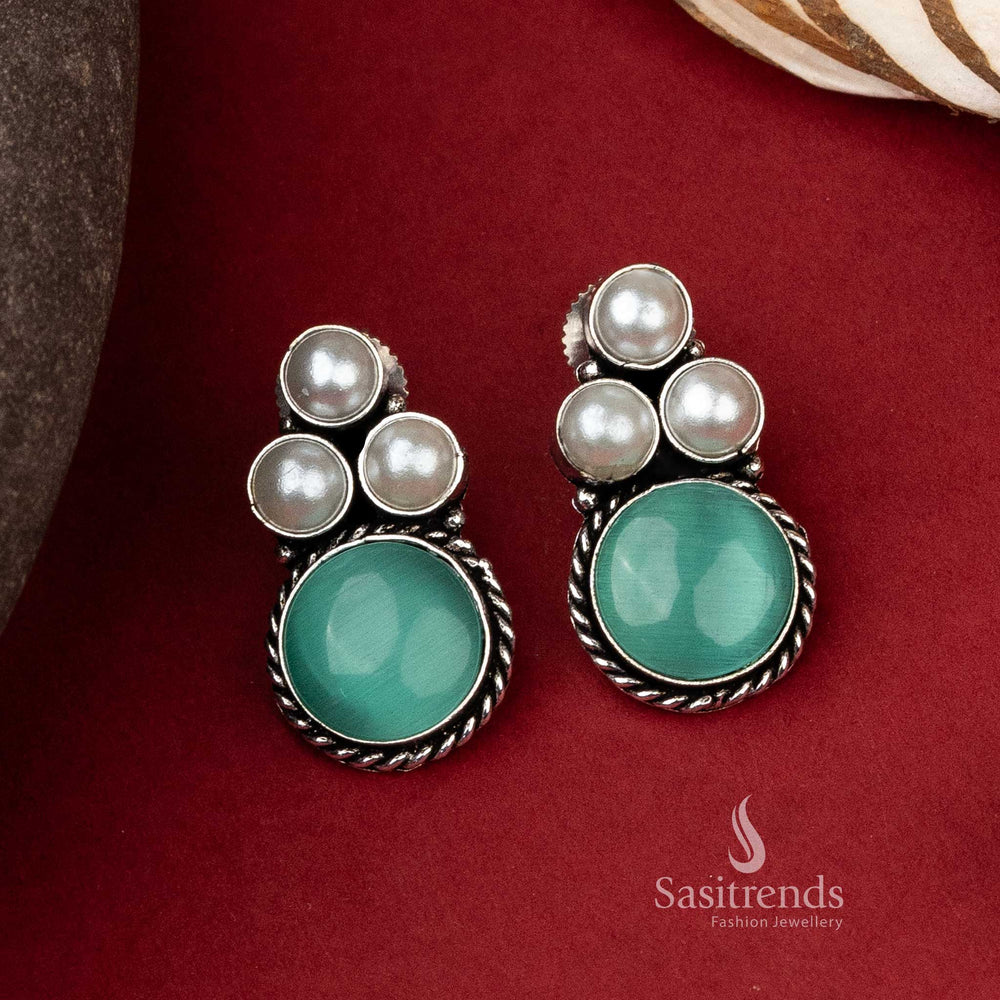 Timeless oxidized silver earrings with a prominent green monalisa stone encircled by a trio of elegant pearls