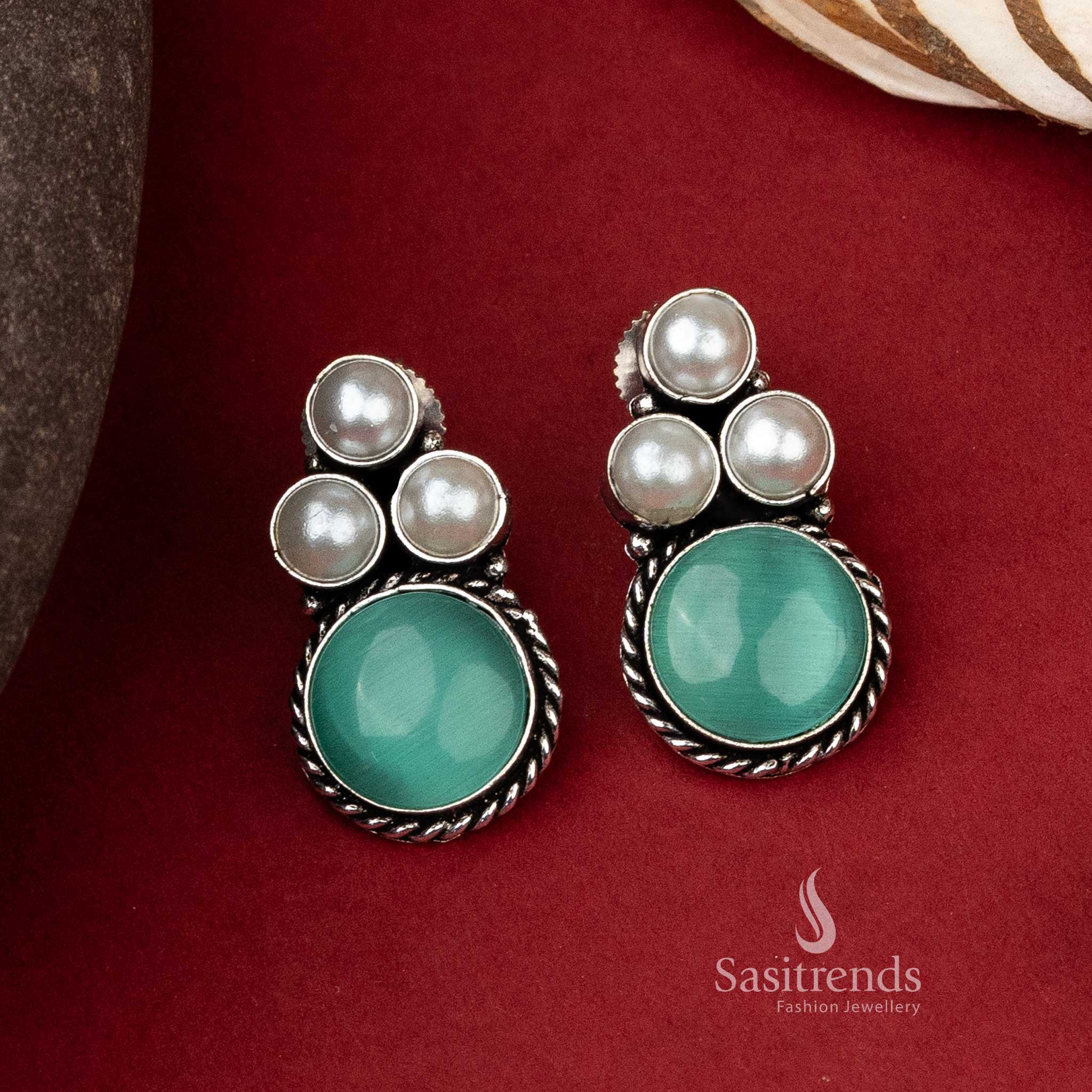 Timeless oxidized silver earrings with a prominent green monalisa stone encircled by a trio of elegant pearls