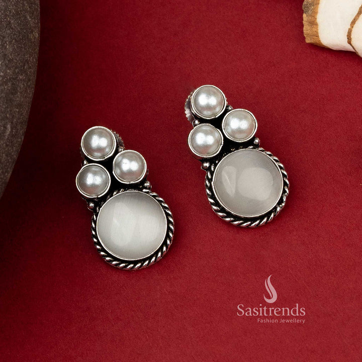 Elegant oxidized silver earrings with a triad of lustrous pearls set above a round grey Monalisa stone