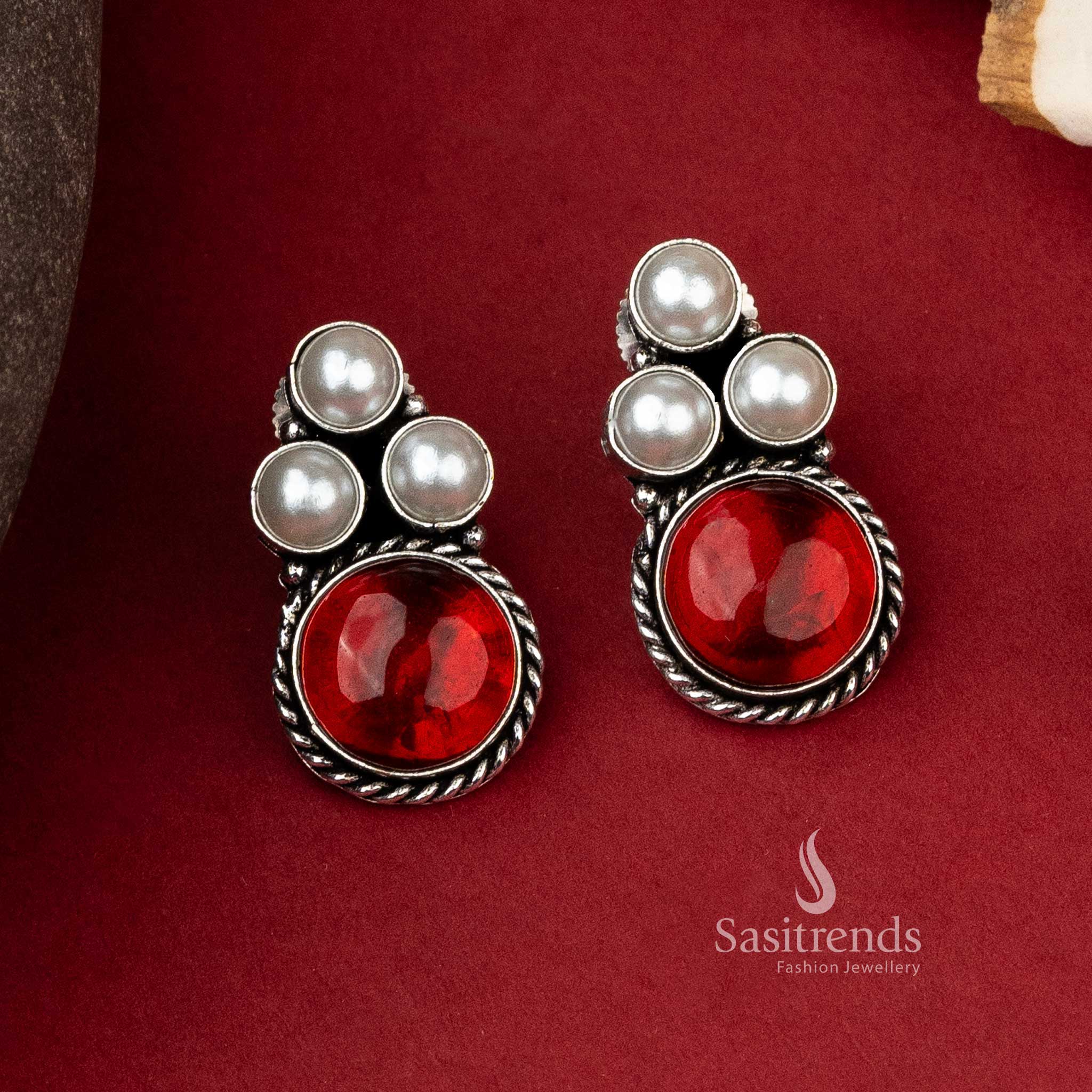 Stylish oxidized silver earrings featuring a trio of pearls with a bold red monalisa stone to accentuate any look