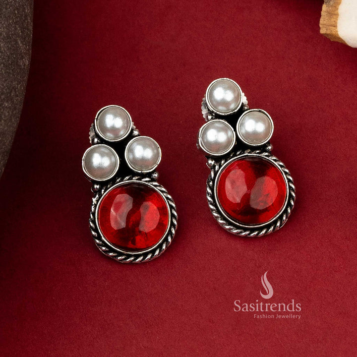 Stylish oxidized silver earrings featuring a trio of pearls with a bold red monalisa stone to accentuate any look