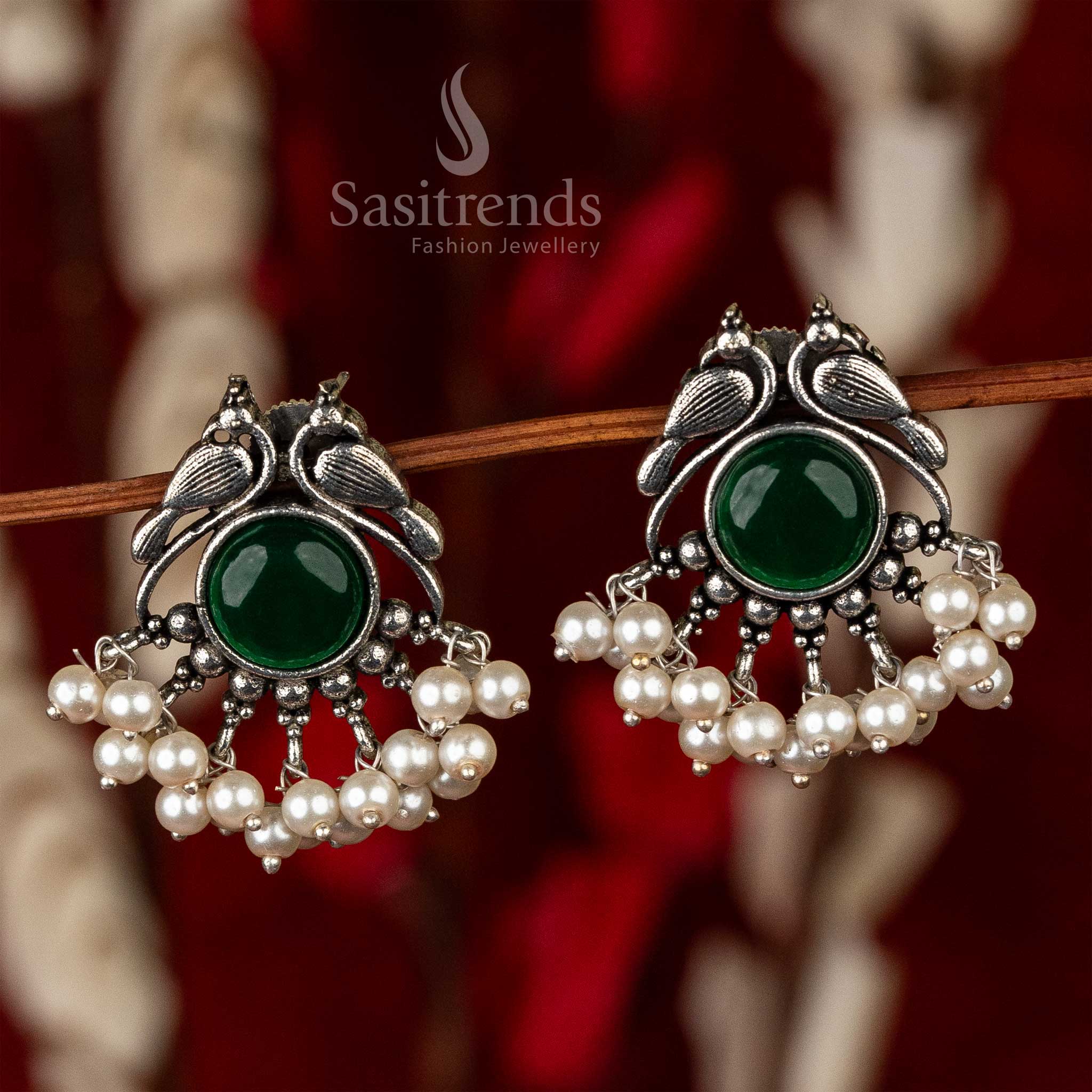 Vintage-style oxidised peacock earrings with an emerald center stone and pearl accents