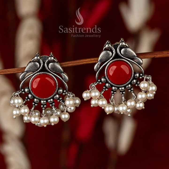 Oxidised peacock earrings with a radiant crimson stone and a fringe of pearls