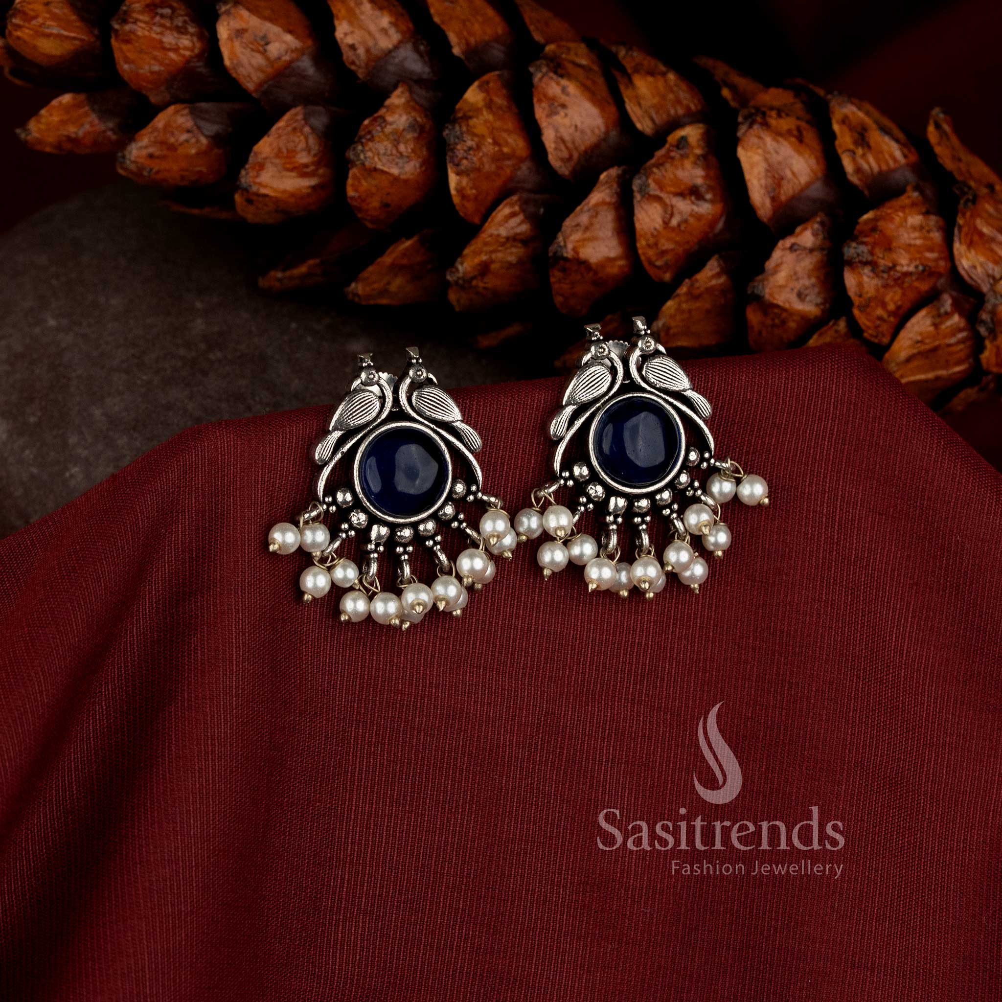 vintage oxidised earrings with detailed peacock motif central stone and pearl embellishments