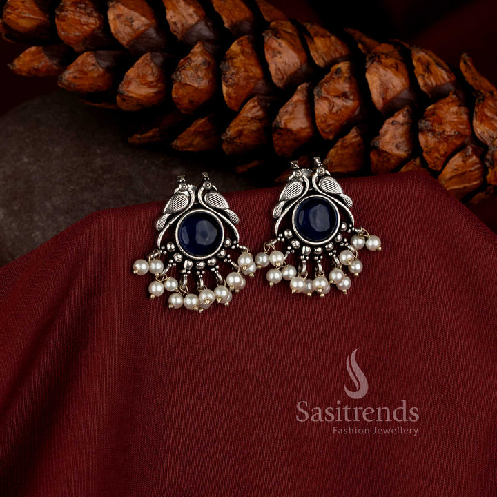 vintage oxidised earrings with detailed peacock motif central stone and pearl embellishments