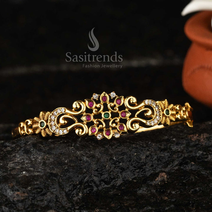 Elegant matte gold-plated temple bangle with multicolor American diamond embellishments, a sophisticated choice for cultural celebrations.