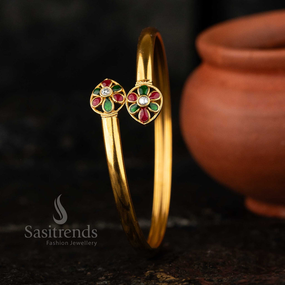 Elegant matte gold-plated brass kada bangle featuring a flower water drop motif with AD Kundan stone and colorful enamel details.