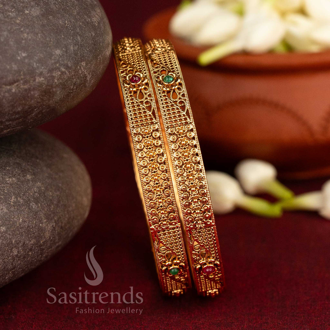 Temple-style antique bangles in matte gold, showcasing ruby-green stones with detailed floral and geometric intricacy – ethnic jewellery radiating devotional heritage from Sasitrends