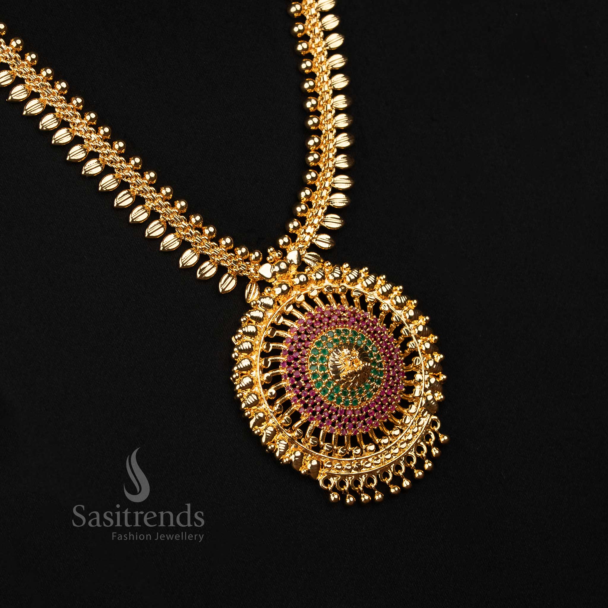Royal ruby-green temple haram with micro gold plating, detailed leaf pattern, sparkling AD stones and divine Lakshmi centrepiece – A majestic jewellery treasure for wedding functions – Sasitrends