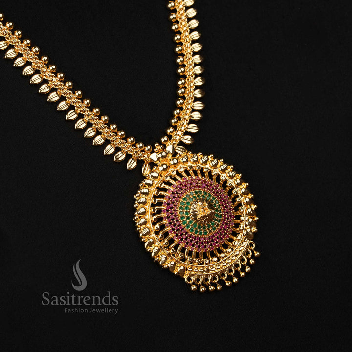 Royal ruby-green temple haram with micro gold plating, detailed leaf pattern, sparkling AD stones and divine Lakshmi centrepiece – A majestic jewellery treasure for wedding functions – Sasitrends