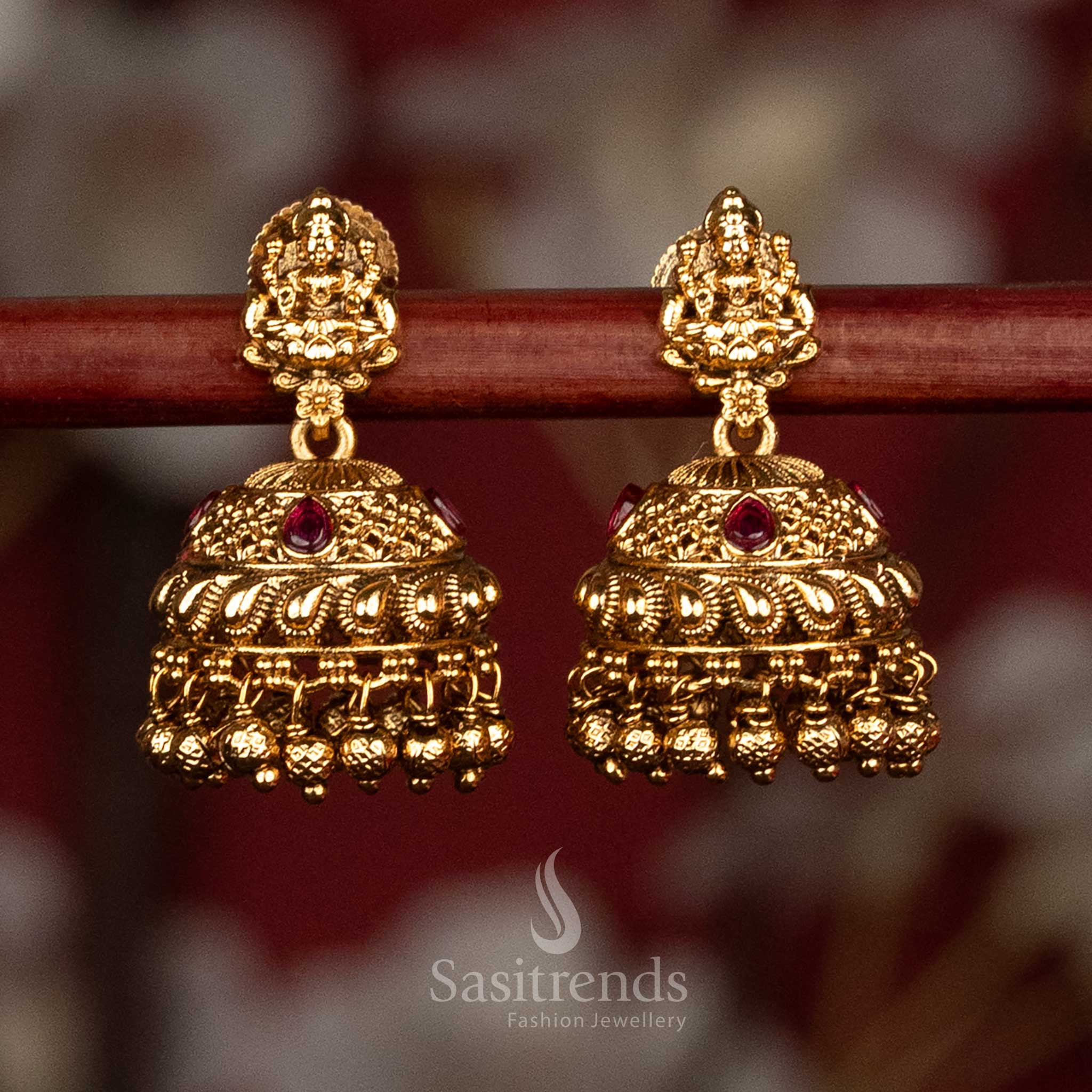 Traditional temple style matte gold ruby AD stone Lakshmi Devi jhumka earrings with sculpted stud motif and rich layered bead detailing, high quality jewellery for saree wear- Sasitrends