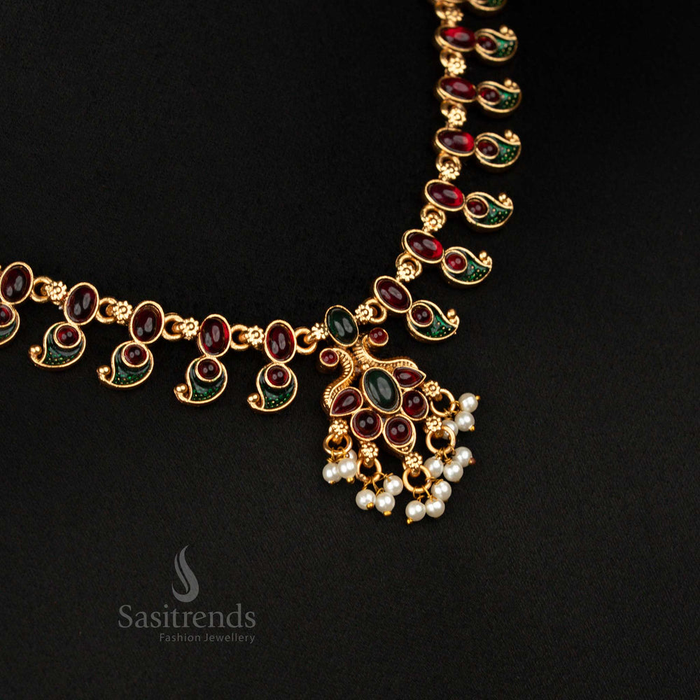 Vibrant ruby-green temple jewellery set in matte gold with stylised leaf motifs and ethereal pearl drops – perfect for enhancing festive bridal attire with a traditional touch – Sasitrends