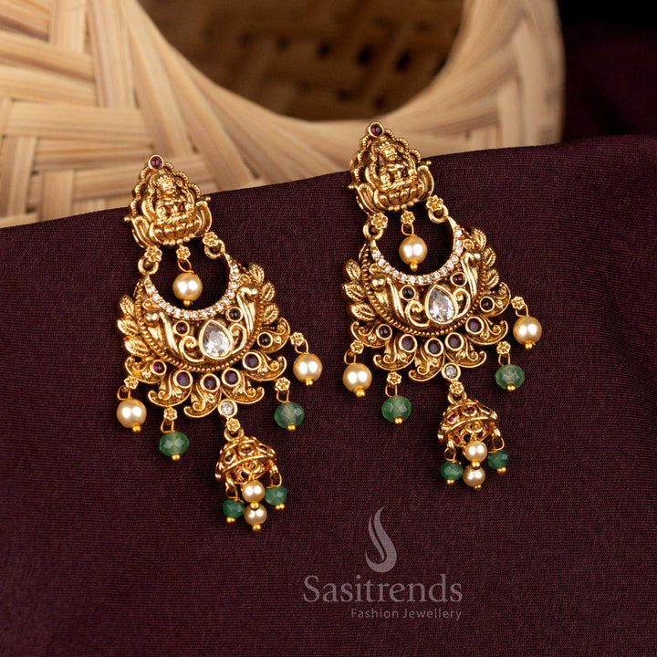 Majestic white ruby Lakshmi temple crescent earrings adorned with ornate floral carvings, radiant AD highlights, matte gold artistry, and regal jhumka elegance – Sasitrends